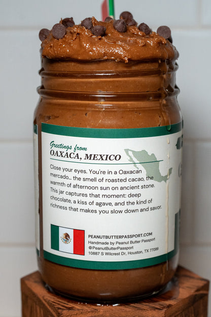 Side photo showing the story pane of a jar of Cacao & Agave peanut butter spread on a wooden block with a white tiled wall background